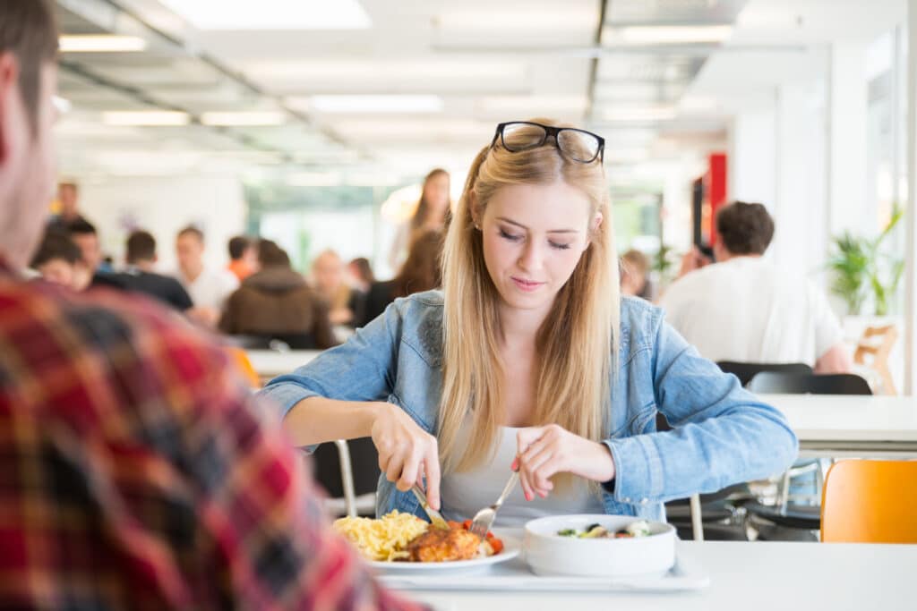 une etudiante mange son dejeuner dans la cafeteria de son ecole